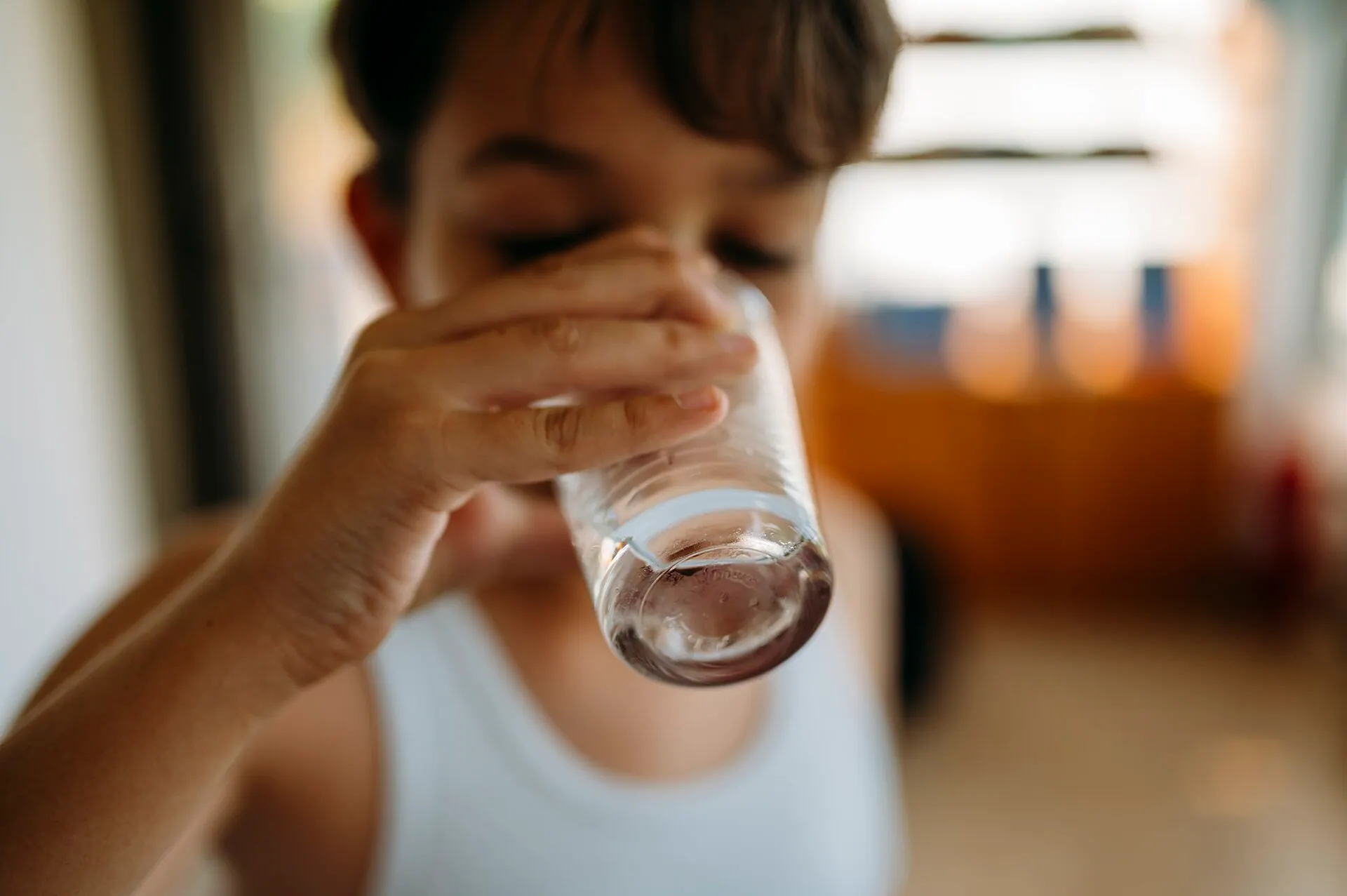 A child drinking a glass of treated water at home